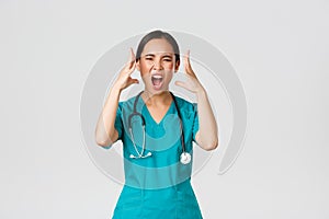 Covid-19, healthcare workers and preventing virus concept. Annoyed and angry, pissed-off asian doctor, female nurse in