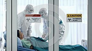 Covid-19 infected patient on bed in quarantine room with quarantine and breakout alert sign at hospital with disease control