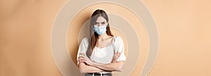 Covid-19 and lifestyle concept. Angry woman look with despise, wearing medical mask, cross arms on chest and stare with