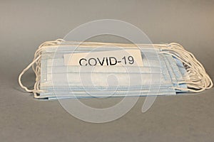 COVID-19. A lot of disposable protective masks on a gray background. Selective focus