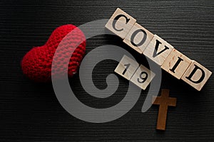 COVID-19 name of Corona virus from Wuhan text word on drak wood background with heart love