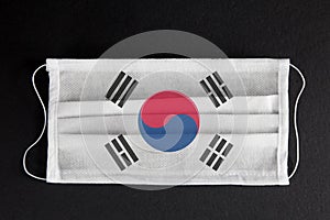 Covid-19 outbreak in South Korea. Coronavirus update in South Korea. South korean flag printed on medical mask on black background