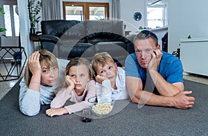 COVID-19 Outbrek. Bored family confined to their home watching tv during coronavirus lockdown