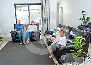 COVID-19 Outbrek. Bored family confined to their home watching tv during coronavirus lockdown