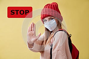 COVID-19 pandemia. Infection spread. Coronavirus outbreak. STOP red sign. Woman in medical mask show avast gesture