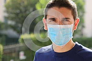 COVID-19 Pandemic Coronavirus Close up of confident handsome man with surgical mask looking at camera outdoor
