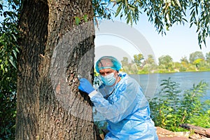 COVID-19 Pandemic Coronavirus. Doctor in medical facial mask hold stethoscope and exam tree patient. M