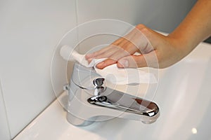 COVID-19 Pandemic Coronavirus Woman Hand Disinfect Faucet Sink with Wet Wipes Alcohol Cleaning Against Coronavirus Disease 2019