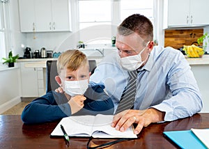 COVID-19 pandemic school lockdowns and self-isolation. Worried parent helping son studying at home
