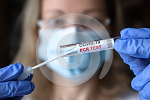 COVID-19 PCR test in doctor hands, nurse in face mask holding coronavirus swab collection kit