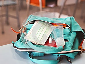 COVID-19 prevention , back  to school  and new normal  concept.Backpack with school supplies ,surgical mask and sanitizer gel  on