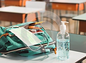COVID-19 prevention , back  to school  and new normal  concept.Front view of  sanitizer gel and  surgical mask in backpack with