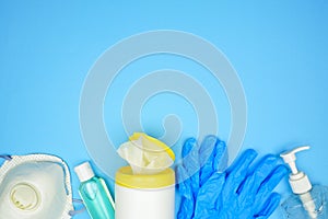 COVID 19 prevention equipment and sanitizers, above view border on a blue background with copy space