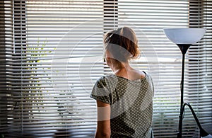 COVID-19 Quarantine mental health. Woman self  at home pensive looking out of window thinking of relationship, employment