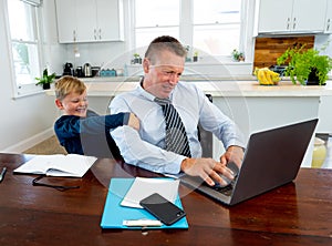 COVID-19 school lockdowns and remote working. Stressed man trying to work from home with bored son