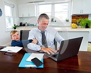 COVID-19 school lockdowns and remote working. Stressed man trying to work from home with bored son