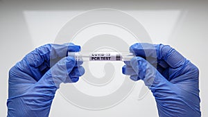 COVID-19 swab collection kit in doctor hands, nurse holds tube of coronavirus PCR test