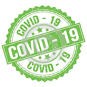 COVID - 19 text on green round stamp sign