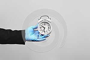 Covid-19 - Time ticking bomb. Businessman holds alarm clock. Quarantine hurting business. Business at home