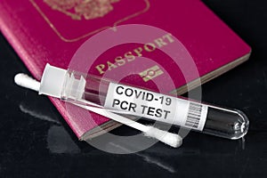 COVID-19, travel and test concept, tube and swab for PCR testing and tourist passport