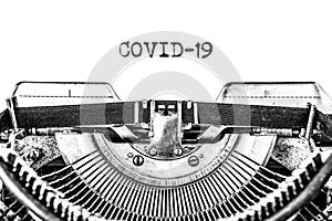 COVID-19 typed on a blank sheet of paper with an antique typewriter.