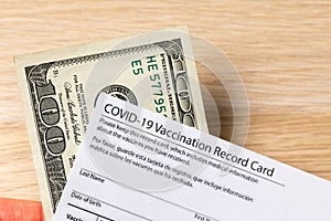 Covid-19 vaccination card and cash money - Image