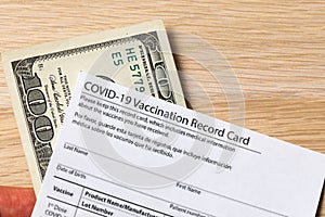 Covid-19 vaccination card and cash money - Image