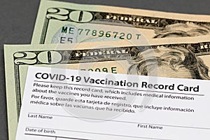 Covid-19 vaccination record card and cash money