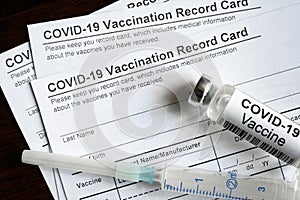 COVID-19 Vaccination Record Card on desk, top view of coronavirus immunization certificate