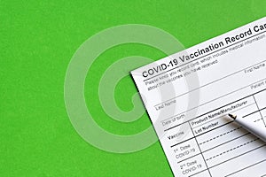 COVID-19 Vaccination Record Card on green background
