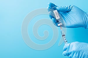 COVID-19 Vaccine vial and injection Needle Syringe against Coronavirus infection in hand of doctor with Nitrile Glove in hospital
