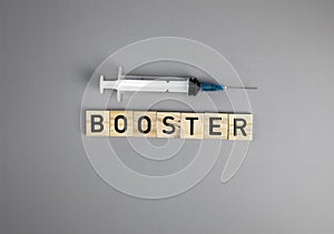 Covid-19 booster shots vaccine text on Gray background Covid-19 booster shots, with syringe top view and copy space photo