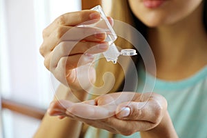 COVID-19 Close up woman hands using wash hand sanitizer gel dispenser, against Novel coronavirus 2019-nCoV at home. Home