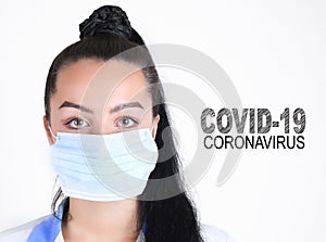 Covid-19 coronavirus desease global pandemic outbreak. A young female doctor in a medical mask with lettering. Close up portrait f photo