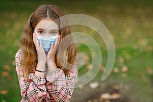 COVID-19 Coronavirus pandemic. Child-girl wearing a mask protecting against the spread of the SARS-CoV-2 virus