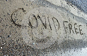 Covid free text written in the sand