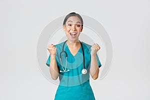 Covid-19, healthcare workers and preventing virus concept. Hopeful and relieved, joyful asian pretty female doctor photo