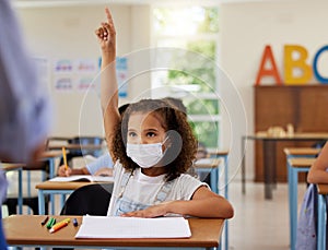 Covid, learning and education with a young girl student wearing a mask and raising her hand to ask or answer a question