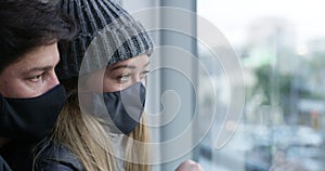 Covid, lockdown and a couple in home with mask on face, writing in breath on window. Health, safety and security in the