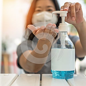 Covid-19 outbreak, coronavirus pandemic prevention with woman wearing n95 face mask cleaning hand using alcohol gel sanitizer photo