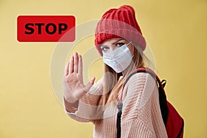 COVID-19 pandemia. Infection spread. Coronavirus outbreak. STOP red sign. Woman in medical mask show avast gesture photo