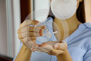 COVID-19 Pandemic Coronavirus mask woman hands close up nurse wash hand sanitizer gel dispenser, coronavirus 2019-nCoV. Home