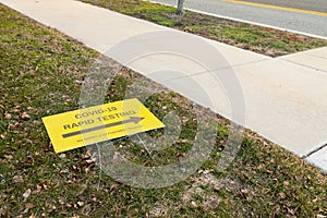 COVID-19 pandemic rapid testing site sign laying on the ground