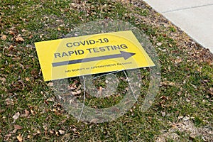 COVID-19 pandemic rapid testing site sign laying on the ground