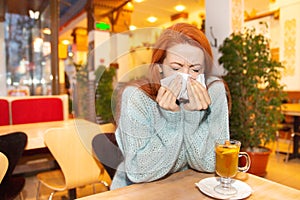 Covid patient in public place. Woman with flu sneezing nose