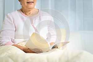 Covid-19 quarantine activity for senior woman read a book stay home to avoid risk