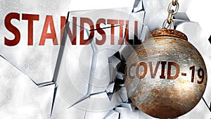 Covid and standstill,  symbolized by the coronavirus virus destroying word standstill to picture that the virus affects standstill