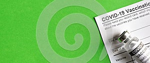 COVID-19 Vaccination Record Card on green background photo
