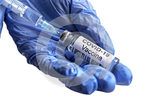 COVID-19 vaccine bottle and syringe in doctorÃ¢â¬â¢s hand for coronavirus cure isolated on white photo