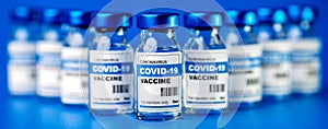 Covid-19 vaccine - coronavirus vaccination bottles. injection vials on blue background photo